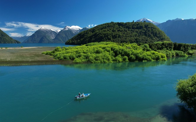 People fly fishing on a small boat on a river in Patagonia.